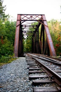 Railroad tours crossing bridge in the woods of northern New Hampshire.