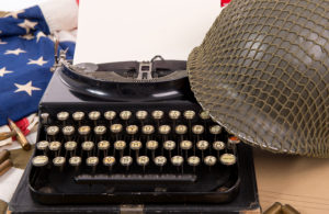 Historic US military helmet of the Second World War with old typewriter