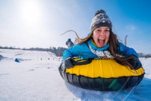 Young Smiling Woman while tubing on a sunny day at Gunstock Mountain